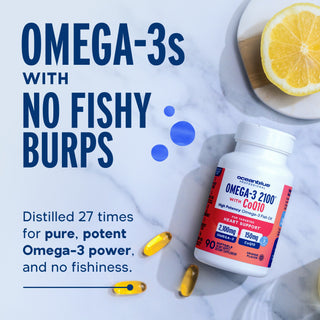 Omega-3 2100 with CoQ10: two capsules and a lemon slice on marble—supports heart health with no fishy burps.