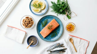 Fresh salmon, sardines, walnuts, chia seeds, and amber softgels arranged in an ocean-blue flat lay