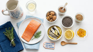 Flat lay of omega-3 foods including salmon, walnuts, chia, flaxseed and amber softgels