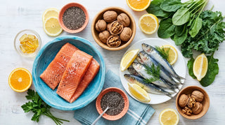 Flat lay of fresh fish, nuts, citrus, and amber softgels on a bright white surface