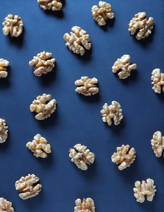 Walnuts that look like mini brains on a blue background